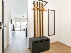 A hallway with a bench, a coat rack, and a framed picture on the wall. - Modern holiday apartment with terrace in Jenbach (Jenbach)