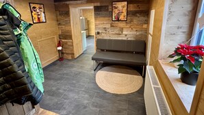 A hallway with wooden walls, a bench, a radiator, and a potted plant. - LostGarden Öblarn Top 1 (Öblarn)
