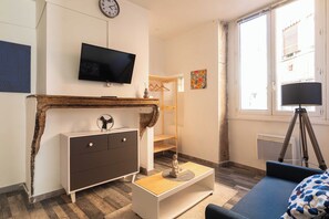 A modern living room with a TV, wooden desk, and a blue sofa. - Cozy Appartement 1br/2p - Vieux Lyon (Lyon)