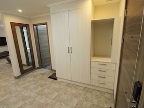Una habitación con armario, espejo y puerta.
