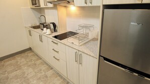 A modern kitchen with a stainless steel refrigerator, a microwave, a toaster, and a coffee maker. - La Grande Residence - Deluxe Suite A (Angeles)