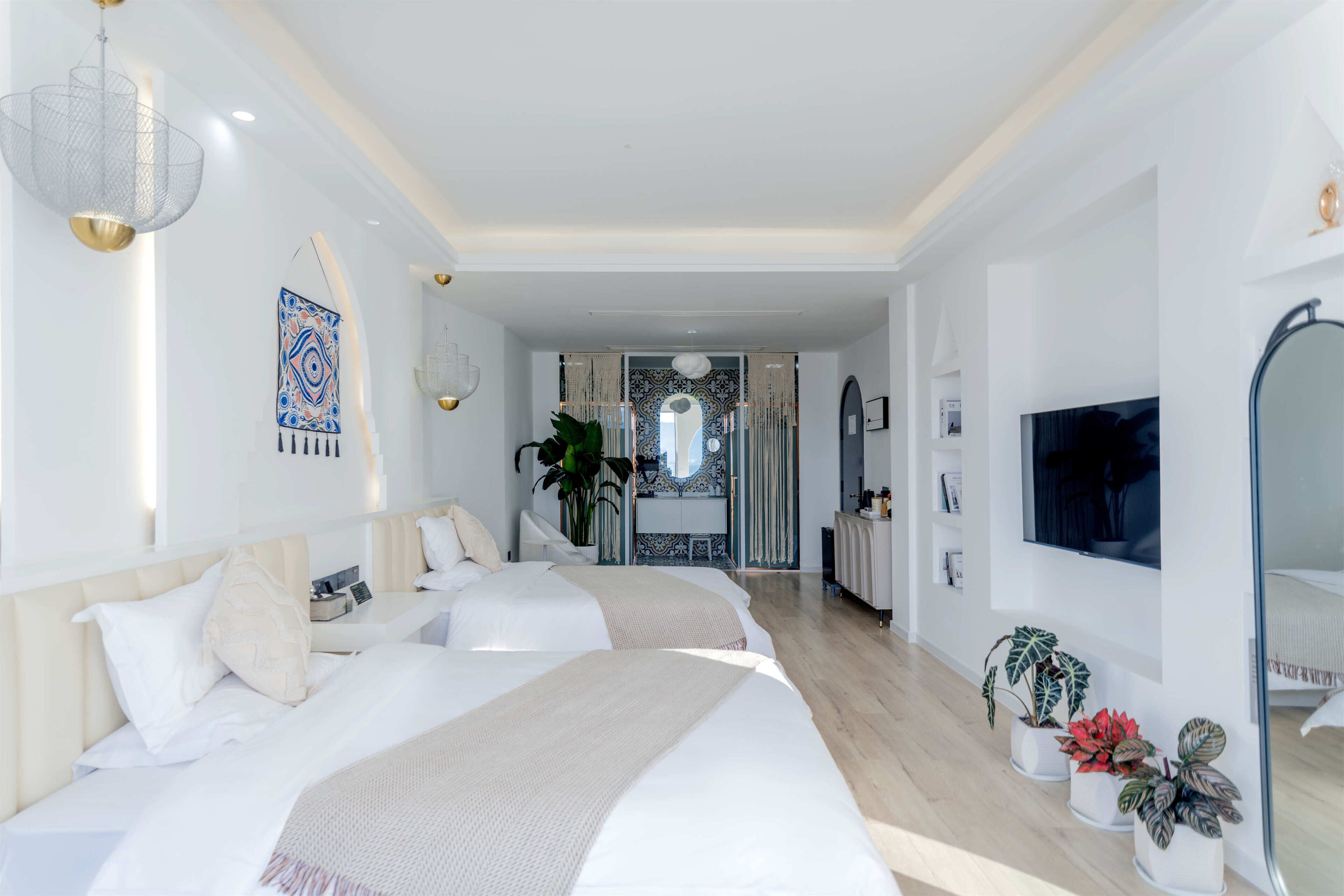 Habitación de hotel moderna con una cama grande, un televisor y una zona de estar con vistas.