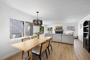 Eine moderne Küche mit Essbereich, weißen Wänden und einem großen Fenster.