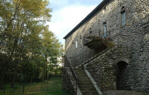 A stone building with a staircase leading to a balcony.