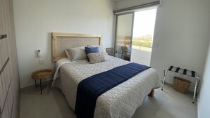 Une chambre à coucher avec un lit, une fenêtre, une chaise et une petite table.