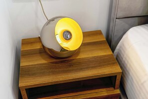 A bedside table with a lamp, a bed, and a wall. - Cozy Studio Syntagma Worn Bldg Entrance (Athina)