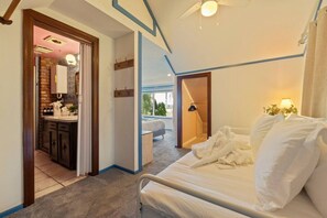 A bedroom with a bed, a bathroom with a sink, and a view of the outdoors.