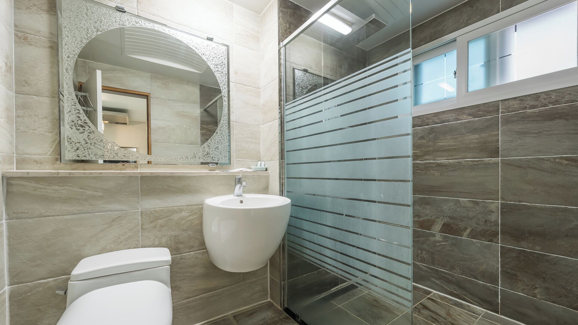 Ein modernes Badezimmer mit Waschbecken, Toilette und Dusche.