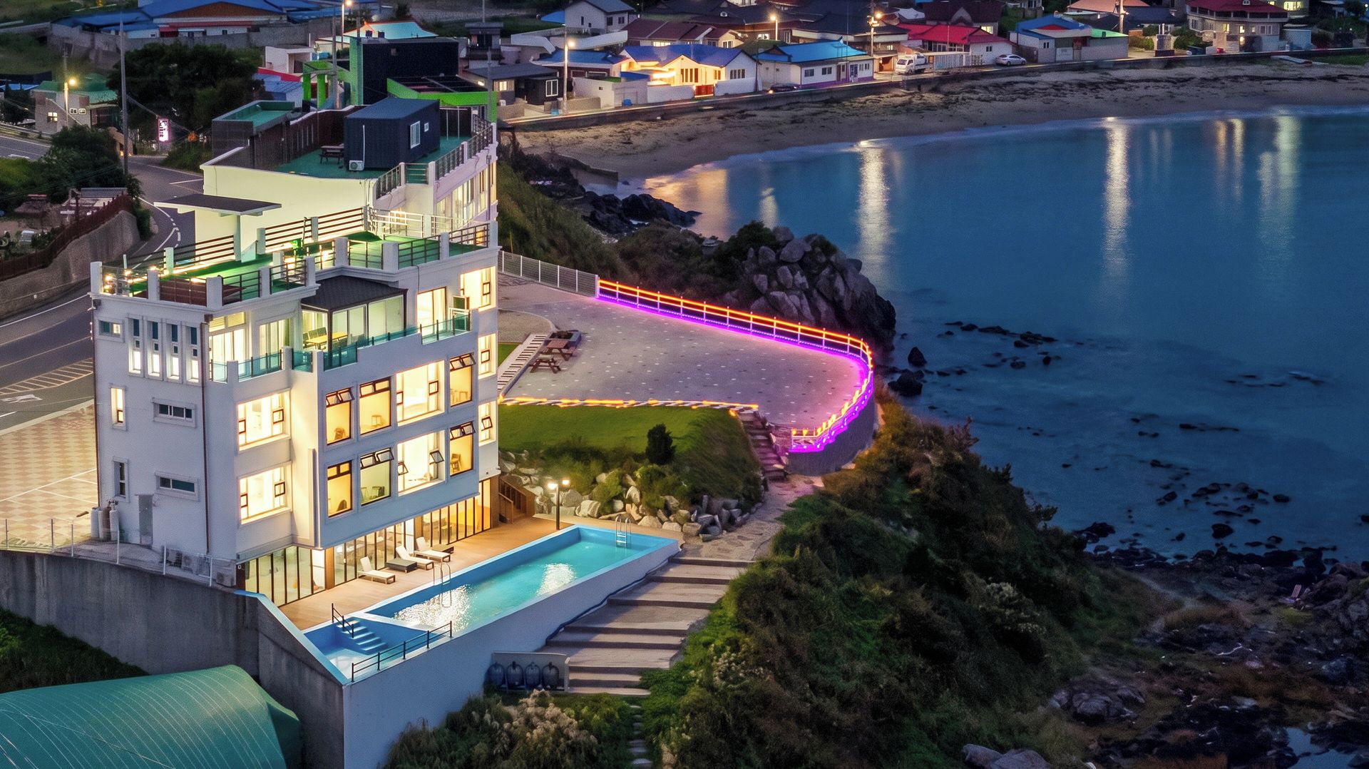 A modern hotel with a rooftop pool, a beachside location, and a view of the sea.