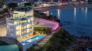 A modern hotel with a rooftop pool, a beachside location, and a view of the sea. - Pohang Pine Wave Pension (Pohang)