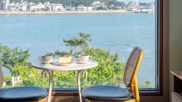 Une table avec deux chaises, donnant sur un plan d’eau et des bâtiments.