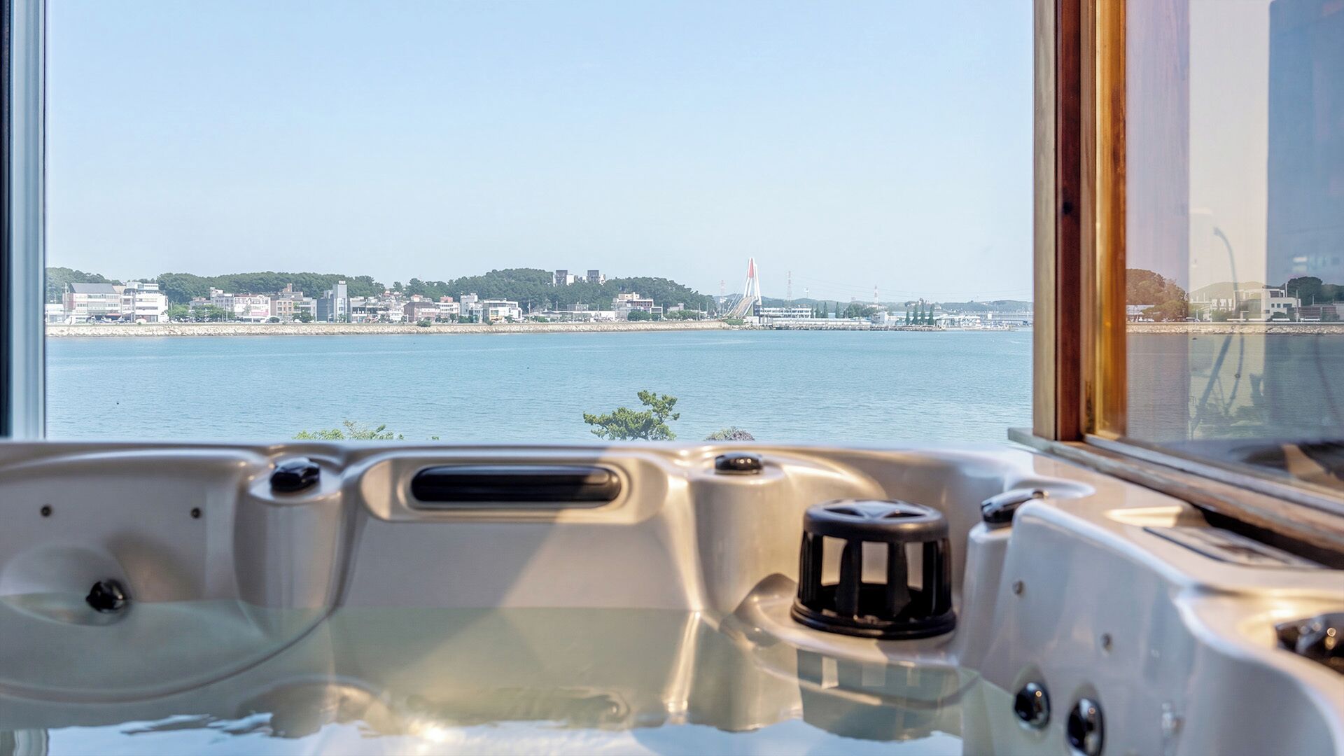 A hot tub with a cityscape view through a window.