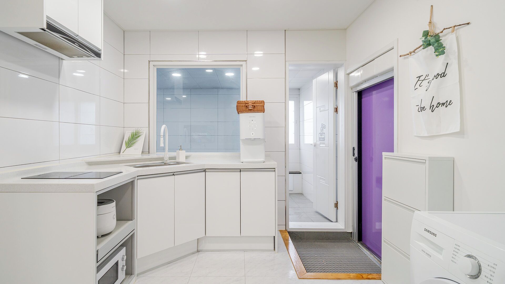 A modern kitchen with white cabinets, a built-in sink, and a water dispenser.