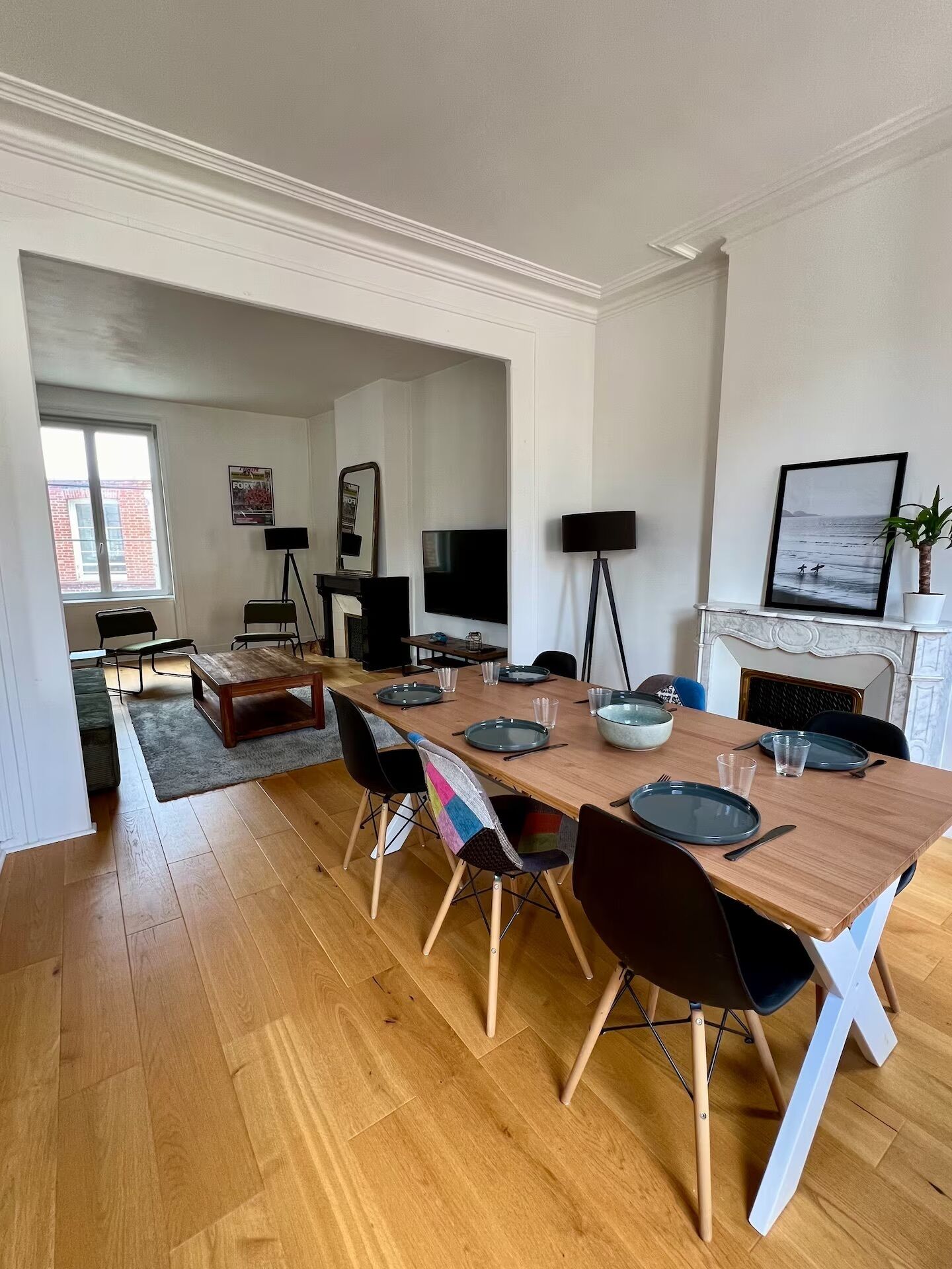 Ein modernes Wohnzimmer mit Essbereich, Kamin und großem Fenster.