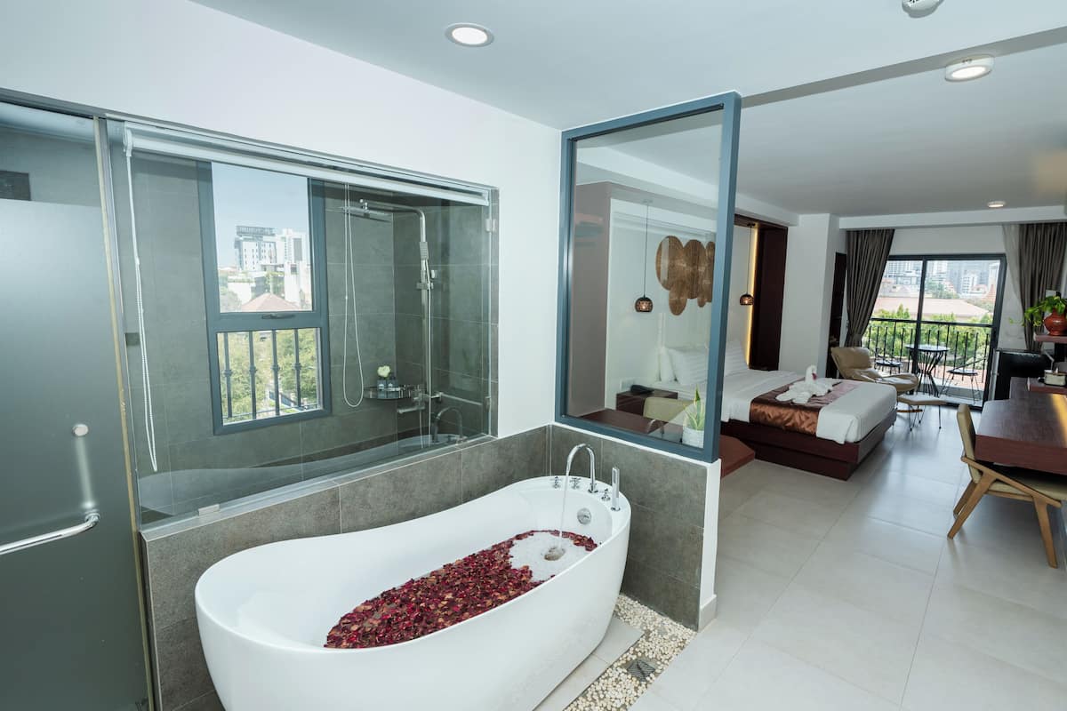 Un baño moderno con una bañera grande, ducha y zona de ducha con mampara de vidrio.