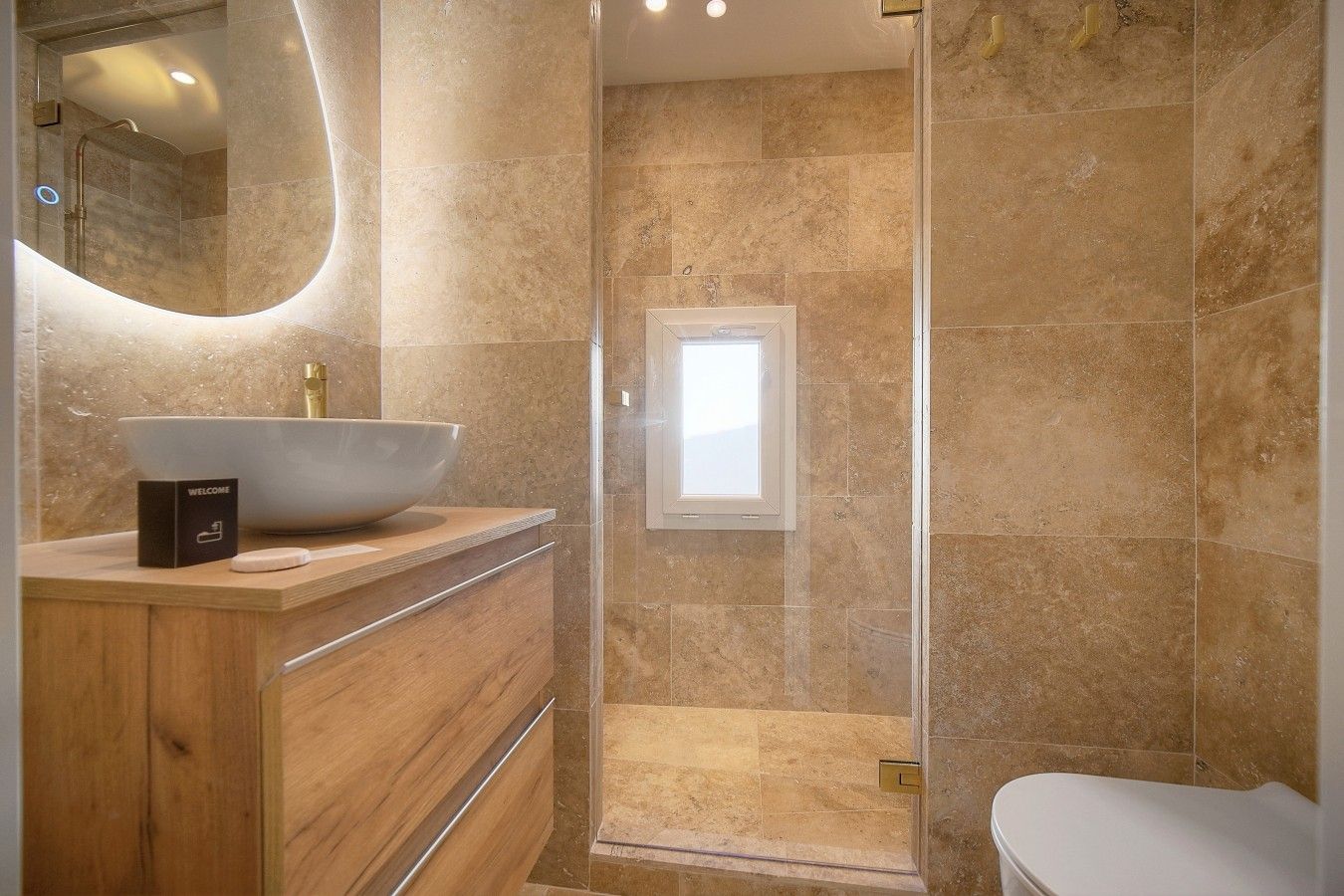 Ein modernes Badezimmer mit einem großen Waschbecken, einer Duschkabine und einer Toilette.