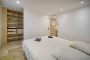A bedroom with a bed, a wooden wardrobe, and a bathroom door. - TOWNHOUSE 3 Bedroom Deluxe Apartment (Cannes)