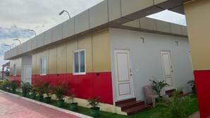 A modern building with a flat roof, multiple doors, and windows. - Aerodon resort (Tirupporur)