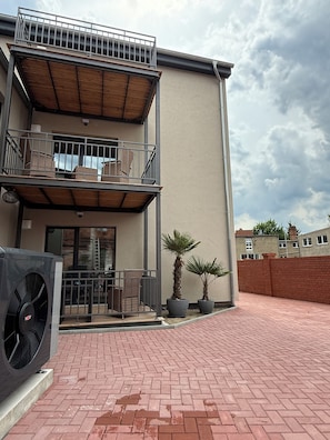 A two-story building with a balcony, outdoor seating, and potted plants. - Modern apartment with 2 bedrooms for up to 6 guests (wittenberge)