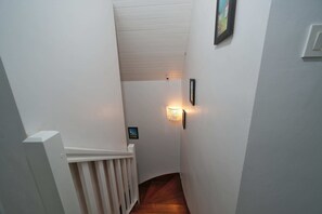A narrow hallway with a white railing, a wooden floor, and a wall-mounted light fixture. - 8 min. walk from the beach - Charming house (10 p.) - in a green setting (Plouhinec)