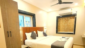 Une chambre à coucher avec un lit, une armoire, un ventilateur de plafond et une fenêtre.