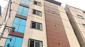 Un immeuble à plusieurs étages, sur lequel on peut lire l’enseigne « Sri Ansh Spa Urban Escape » et l’enseigne « MI Hotel ».