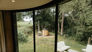 A room with large windows, a wooden floor, and white furniture. - Holiday Home in Wilsum With Hottub (Wilsum)