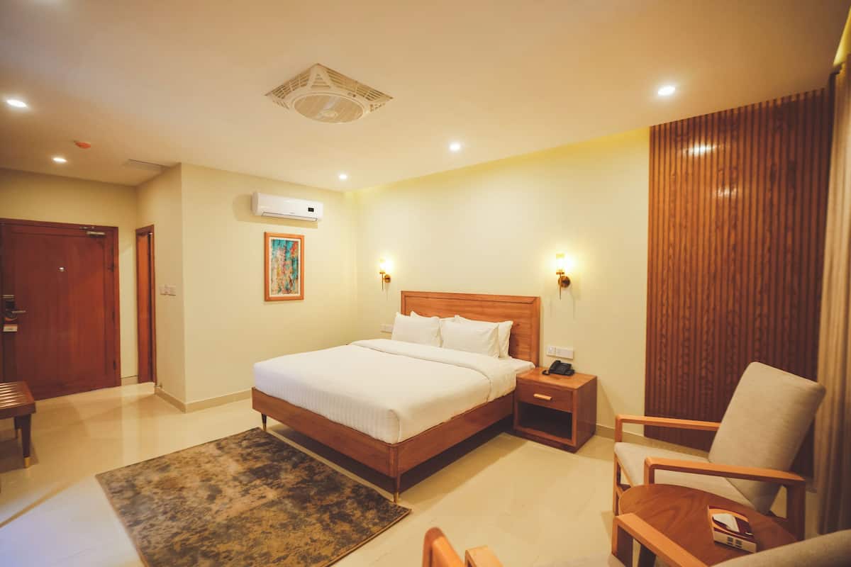 A hotel room with a wooden bed, bedside tables, a chair, and a rug.