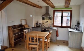 Una cocina con muebles de madera, una ventana y un salpicadero de azulejos.