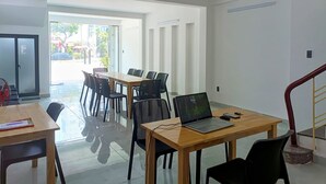 Ein modernes Interieur mit einem Holztisch, schwarzen Stühlen, einem Laptop und einem roten Fächer.