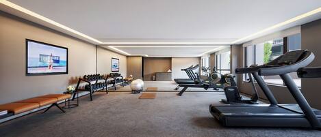 A gym with treadmills, exercise balls, and a bench.