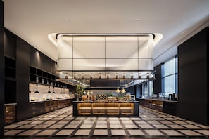 Une cuisine moderne dotée d’un îlot central, de luminaires suspendus et d’un carrelage à motifs géométriques.