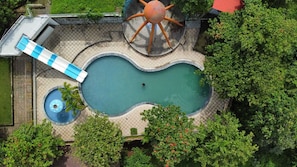An aerial view of a swimming pool with a slide, a circular water feature, and surrounding greenery. - Heaven Hill Resort (Lalonde)