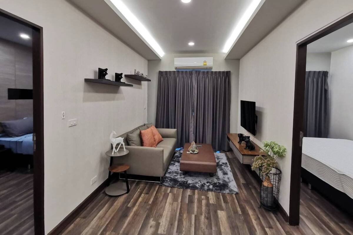 Una sala de estar moderna y bien iluminada con un sofá, una mesa de centro y un televisor.