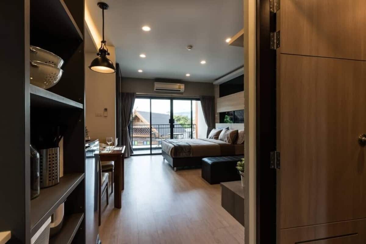 Un interior moderno con una zona de cocina, una mesa de comedor, un sofá y un amplio ventanal con vistas.