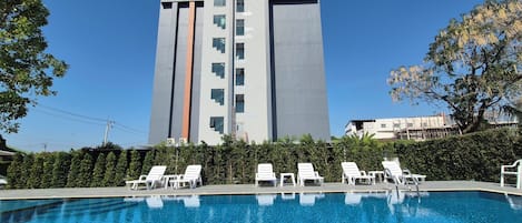 Ein modernes Gebäude mit Pool und Liegestühlen.