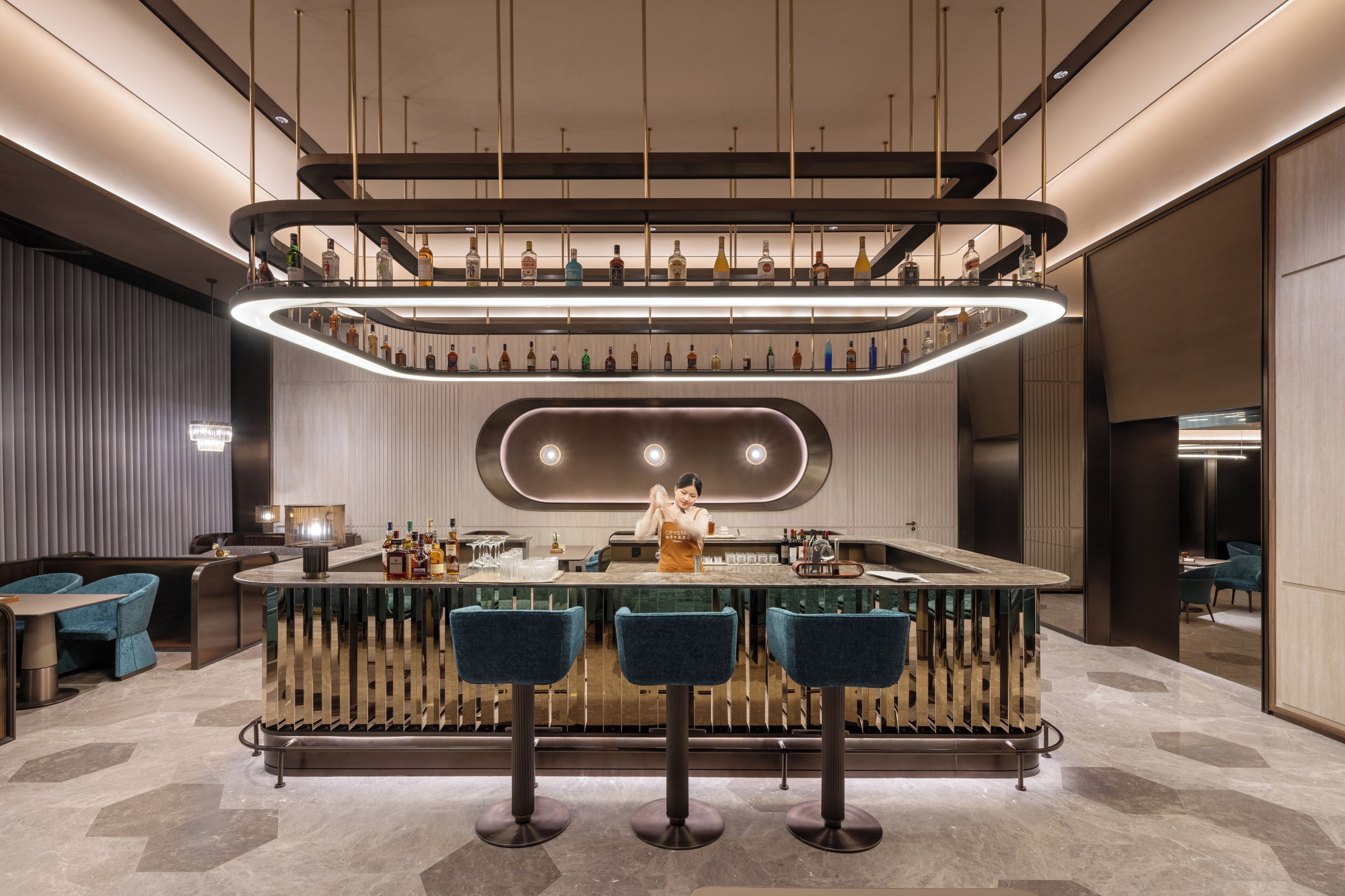 A modern bar area with a central bar counter, three bar stools, and a bartender.