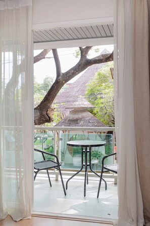 A room with a glass door leading to an outdoor area with a table and chairs. - Stay Calm – Pool• Gym• Balcony (Suthep)