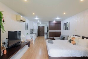 A modern hotel room with a bed, a desk, a TV, and a kitchenette. - Stay Calm – Pool• Gym• Balcony (Suthep)