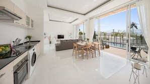 Een moderne keuken met een eetgedeelte, een zithoek en een balkon met uitzicht.