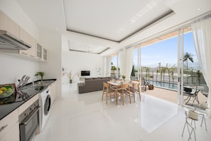 Eine moderne Küche mit Essbereich, Wohnzimmer und einem Balkon mit Blick.