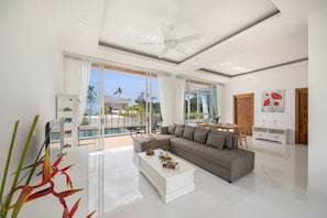Ein modernes Wohnzimmer mit einer Couch, einem Couchtisch und einem Deckenventilator.