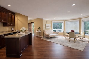 A spacious kitchen with dark wood cabinets, a marble countertop, and a large island.