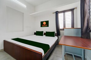A hotel room with a bed, a desk, a window with curtains, and a sign on the wall. - KAYILAI RESIDENCY (Coimbatore)
