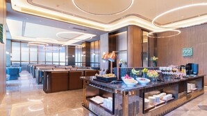 A modern hotel lobby with a buffet, seating area, and a reception desk. - Crystal Hotel Qingdao Hi-Tech Convention (Qingdao)