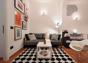 Un salon moderne avec un canapé, une table basse et un tapis à motifs.
