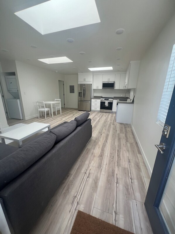 A modern kitchen with white cabinets, a built-in oven, and a microwave.