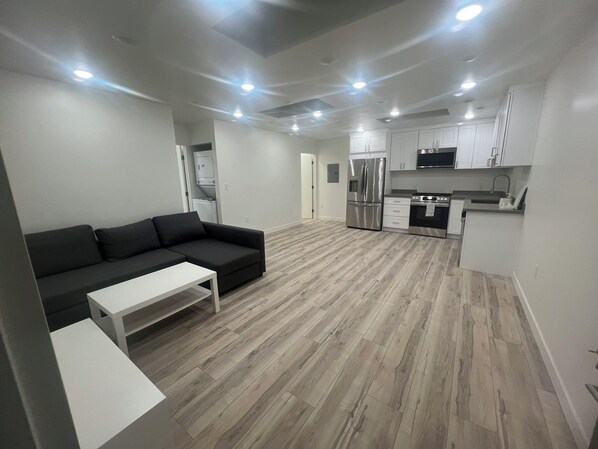 A modern apartment with a living area, kitchenette, and a dining area.