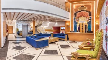 A spacious lobby with a curved ceiling, a reception desk, and a staircase.