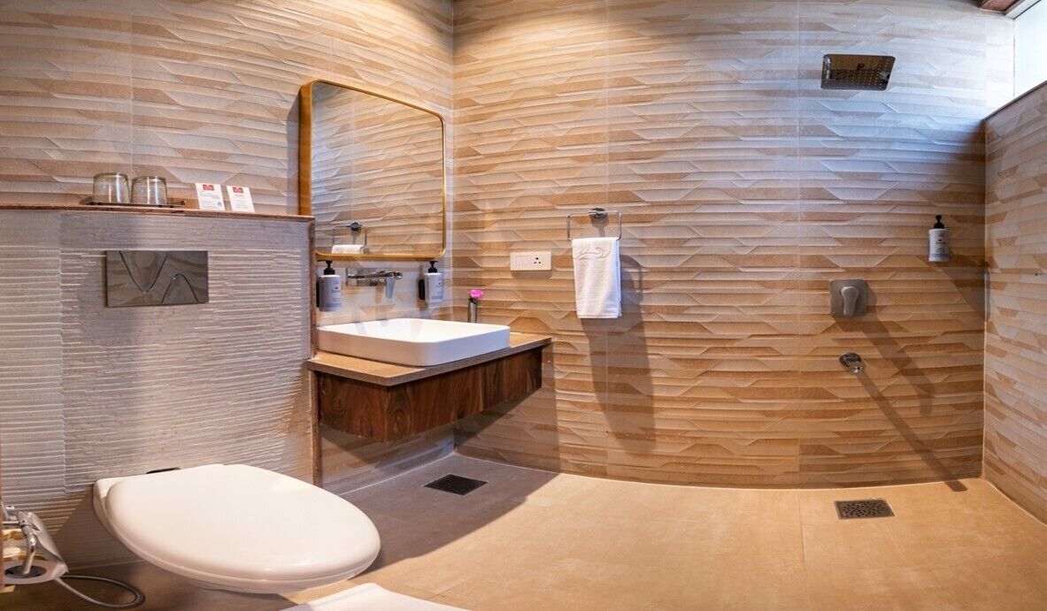 A modern bathroom with a wooden wall design, a white sink, a mirror, and a shower area.